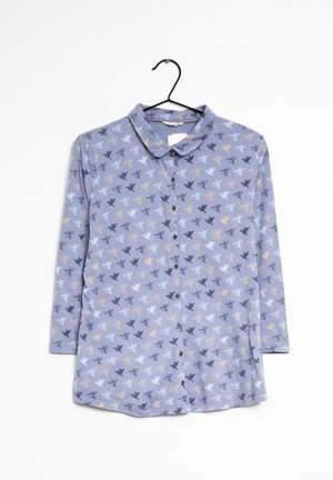 Chemise bleu clair à manches longues avec col, fermeture à boutons et motif intégral d'oiseaux en tons noir, blanc et or.