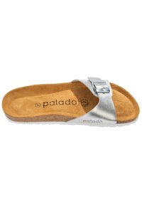 Silverfärgad slidesandal med en bred rem som har en metallspänne. Fotbädden är texturerad brun, tillverkad av ett material som liknar mocka, och är dämpad.