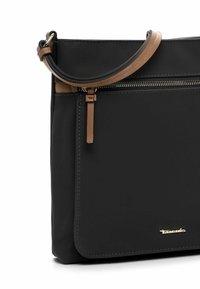 Black synthetic crossbody bag with brown accents, featuring a zippered pocket, smooth texture, and gold logo detail on the front.