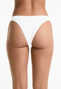 Witte bikini onderkant met een gematigde snit, gladde stoftextuur, en een minimalistisch design, met een lage tailleband.