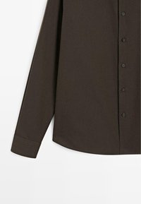 Dark brown button-up shirt with a smooth texture, long sleeves, and black buttons, featuring a rounded hem and a structured collar.