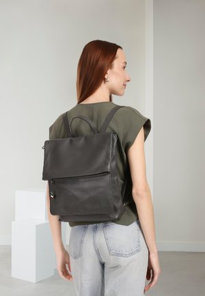 Grijze leren rugzak met een gestructureerde afwerking, voorzien van een bovenvlakklep, een voorvak met ritssluiting en verstelbare bandjes.