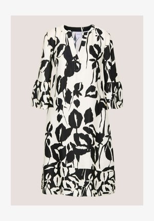 Schwarz-weißes Blumenkleid mit V-Ausschnitt, 3/4-Puffärmeln und legerer Passform; verfügt über ein auffälliges Blattmuster auf hellem Hintergrund.
