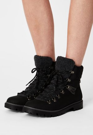 Bottes de randonnée noires avec une tige texturée, un col en feutre gris, des œillets métalliques et une semelle en caoutchouc durable, dotées d'un design à lacets sur le devant.