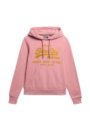 Felpa rosa con cappuccio, dotata di una tasca frontale a marsupio. Stampa dorata con la scritta "Vintage SuperDry" e caratteri giapponesi. Materiale in cotone.