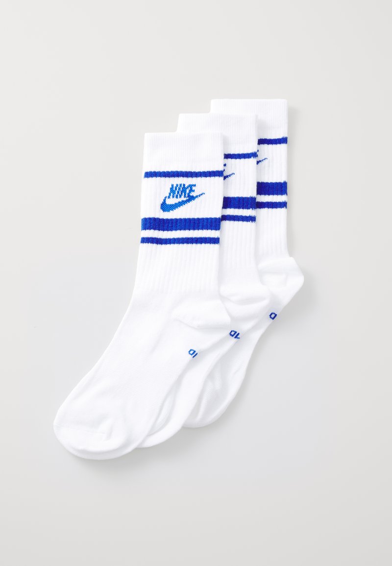 Trois paires de chaussettes blanches à mi-mollet avec des rayures bleues et un logo Nike bleu, fabriquées en coton côtelé. Texture douce, design athlétique.