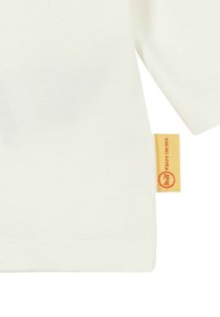 Witte katoenen T-shirt met korte mouwen, met een textuurstof en een gele label met een rood rond logo aan de zijkant.