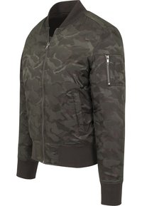 Blouson aviateur camouflage en tons vert foncé, doté d'une fermeture éclair avant, de poignets côtelés et d'une poche zippée sur la manche pour le rangement.