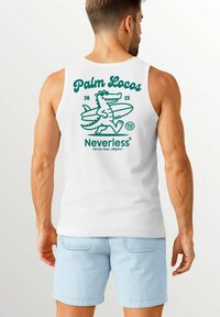 White tank top featuring a green graphic design of an alligator with a surfboard, text "Palm Locos 2025" and "Neverless" below, set against a light background.