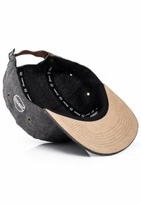 Cappello con corpo in tessuto nero e visiera in suede tan perforato. Presenta una cintura in pelle regolabile e un marchio interno.
