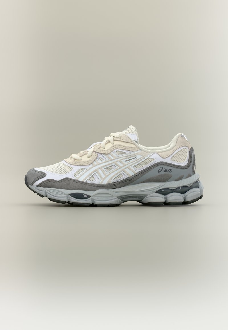 Bielo-sivé športové topánky s sieťovinovým zvrškom, polstrovaným golierom a hrubou, polstrovanou podrážkou s šedým prvkom a logom.