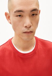 Rode katoenen t-shirt met een ronde hals en een gladde textuur. Heeft een witte binnenkraag en een minimalistisch ontwerp.