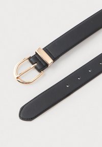 Schwarzer Leder-Gürtel mit abgerundetem Ende, goldfarbener, gebogener Schnalle und rechteckiger goldener Gürtelschlaufe auf hellem Hintergrund.