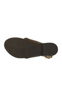 Brown leather sandal with a textured sole, outlined straps, and a gold-tone buckle. Features a flat, non-slip bottom with horizontal grooves.