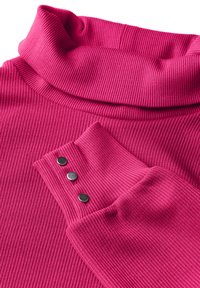 Roze geribbelde coltruik met een opgevouwen kraag en drie zwarte knopen op de mouw. De stof heeft een gestructureerde uitstraling.