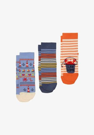 Tre par farverige sokker: blå med nautiske motiver, marineblå med flerfarvede striber og orange med krabber og teksten "CLAW SOME".