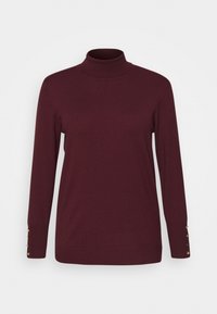 Pull à col roulé bordeaux en tissu tricoté doux, avec des manches longues et des accents de boutons dorés aux poignets.