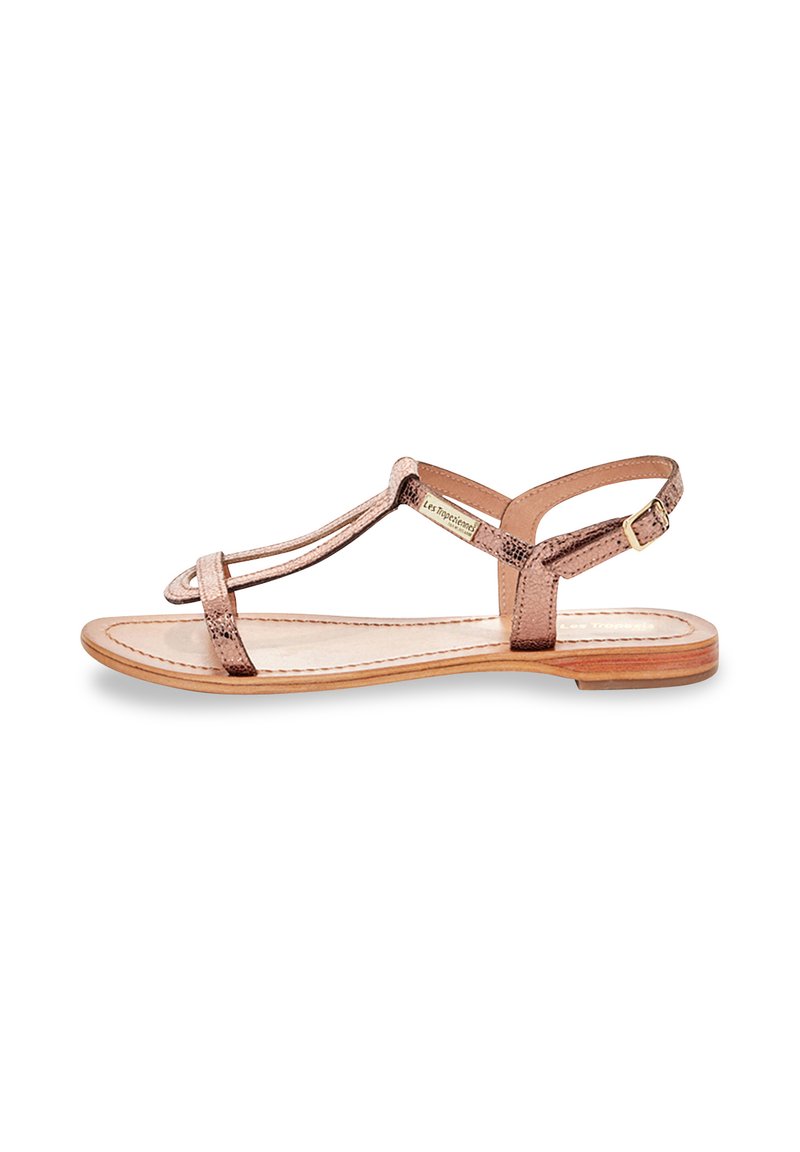 Rosa guld metallisk sandal med två smala remmar över foten och vristen, platt sula och en liten spänneaccent. Slät textur och minimalistisk design.