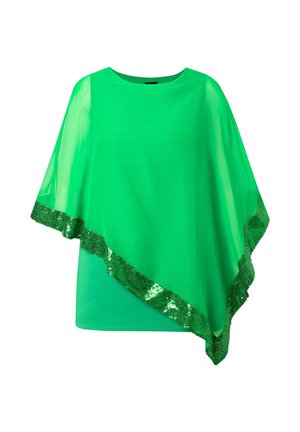 Poncho transparent vert vif avec ourlet asymétrique et bordure à sequins, porté sur un haut vert uni à encolure ronde.