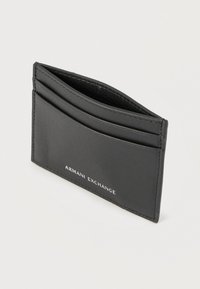Μαύρο δερμάτινο θήκη καρτών με πολλαπλές υποδοχές και το λογότυπο "Armani Exchange" τυπωμένο με λευκά γράμματα στην πρόσοψη.