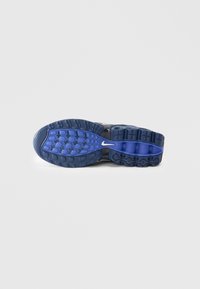 Nikeova potplat tenisice u crnoj boji s plavim srednjim dijelom. Tekstura s raznim uzorcima i bijelim logotipom. Sadrži istaknute elemente za prianjanje.
