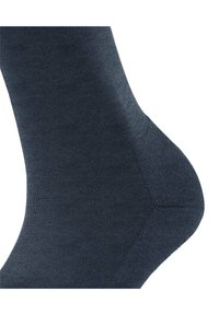Calzino grigio scuro realizzato in un tessuto liscio e elastico. Presenta un tallone rinforzato e una punta senza cuciture per il massimo comfort.