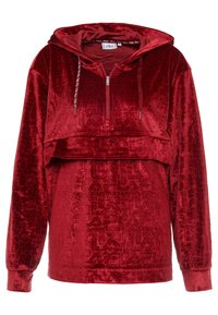 Sweat à capuche rouge velours avec un design court, une fermeture éclair à moitié ouverte à l'avant et un motif géométrique en relief. Comprend des cordons de serrage et des manches longues.