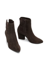Stivali alla caviglia in suede marrone scuro con cerniere laterali e tacchi a blocco, con punte affusolate, esposti su uno sfondo bianco.