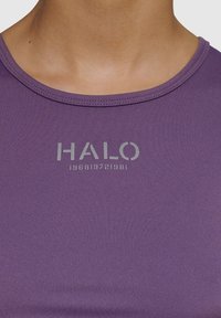 Fioletowa koszulka sportowa z okrągłym dekoltem, charakteryzująca się gładką fakturą i szarym logo 'HALO' z cyframi nadrukowanymi poniżej.