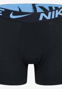 Black cotton boxer briefs with a light blue stretchy waistband featuring the Nike logo. The fabric has a smooth texture and tight fit.