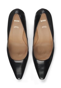 Black patent leather heels with a pointed toe design. Inner lining is beige, featuring brand and technology logo printed in white.