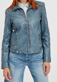 Giacca di pelle blu con chiusura a zip, dettagli testurizzati e tasche laterali, dal design aderente e finitura leggermente lucida.