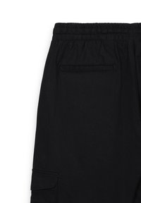 Schwarze Jogginghosen aus weichem Stoff, mit einem elastischen Bund und einer Gesäßtasche mit horizontaler Öffnung. Gerades Bein Design.