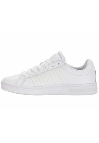 Baskets blanches avec une tige synthétique lisse, comportant trois bandes en relief, des lacets plats et une semelle en caoutchouc texturé.