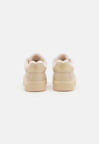 Beige High-Top-Sneaker mit flauschigem Futter, glattem Lederobermaterial und Gummisohle. Goldenes Logo-Detail an der Ferse.