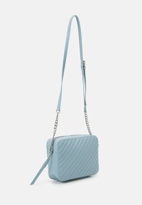 Borsa a tracolla azzurro chiaro in pelle testurizzata, con dettagli a rombi diagonali, cinturino regolabile e un'accattivante catena argentata.