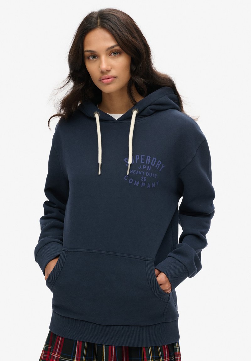 Sudadera azul marino hecha de una mezcla de algodón; cuenta con un bolsillo canguro en la parte frontal y detalles en blanco en los cordones; logotipo de marca impreso en púrpura.