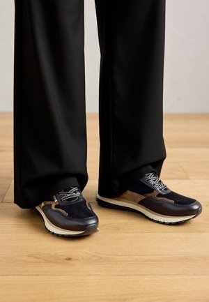 Sport shoes in navy and black with brown accents, textured suede and smooth leather, round toe, and white sole with grip detail.