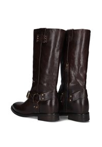 Bruine leren kniehoog laarzen met een gestructureerde afwerking, een ritssluiting aan de zijkant, een gespsieritem en een ronde neus. Gelaagde hak en details met metalen studs.