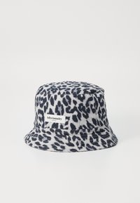 Pălărie tip bucket din bumbac cu imprimeu de leopard în nuanțe de bleumarin și gri, cu un eticheta cusută. Are o textură moale și o margine lata pentru protecție împotriva soarelui.