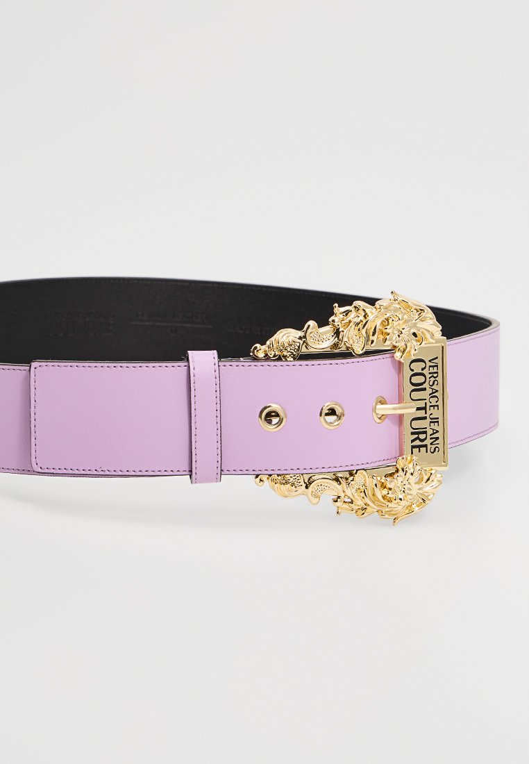 Lila Leder Gürtel mit einem breiten Design, ausgestattet mit einer goldenen, verzierten Schnalle und Logodetails. Sanfte Textur mit metallischen Akzenten.