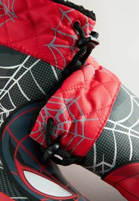 Botte imperméable rouge et noire avec un motif en toile d'araignée, tige matelassée, système de laçage complexe et un emblème d'araignée frappant sur le côté.