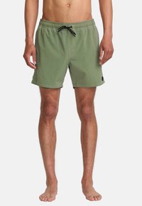 Shorts de bain verts avec taille à cordon, poches latérales et un petit logo en patch sur l'ourlet inférieur. Fabriqués en tissu léger.