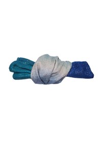 Tessuto glitterato blu e turchese attorcigliato in un nodo su uno sfondo bianco.