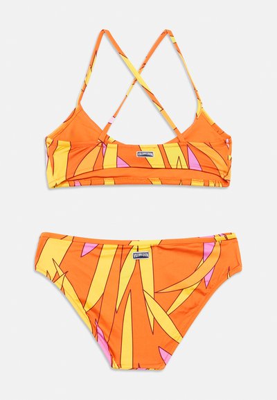 Σετ πορτοκαλί μπικίνι με σχεδιασμό λουριών που διασταυρώνονται. Το τοπ έχει ζωηρό μοτίβο φύλλων με κίτρινες και ροζ λεπτομέρειες.
