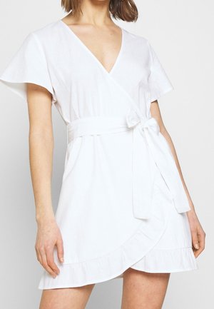 Vestido envolvente blanco en una tela ligera. Mangas cortas con vuelo, escote en V, detalle de cinturón atado y dobladillo con volantes. Diseño informal.