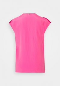 Top sans manches rose en tissu lisse, avec un col haut et une fermeture à boutons dans le dos, doté d'un ourlet arrondi.