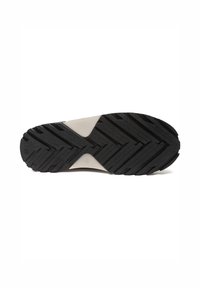 Suela de zapato con patrón de zigzag negro y sección central beige, diseñada para tracción y durabilidad.