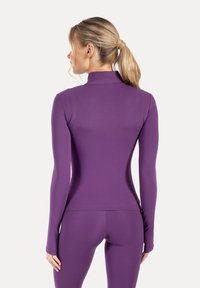 Purple long-sleeve top with a high collar, made of stretch material, fitted silhouette, flat seams, and smooth texture.