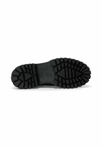 Suela de zapato de goma negra con un patrón de banda de rodadura resistente, que presenta surcos y crestas profundos para tracción y estabilidad. Superficie plana y uniforme.